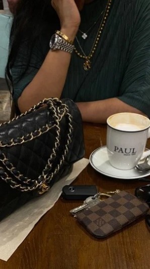 Coffee and a designer handbag on a cafe table
